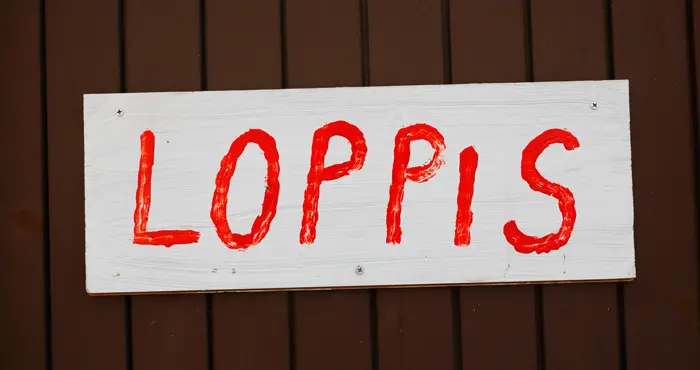 En skylt på en vägg med texten Loppis.