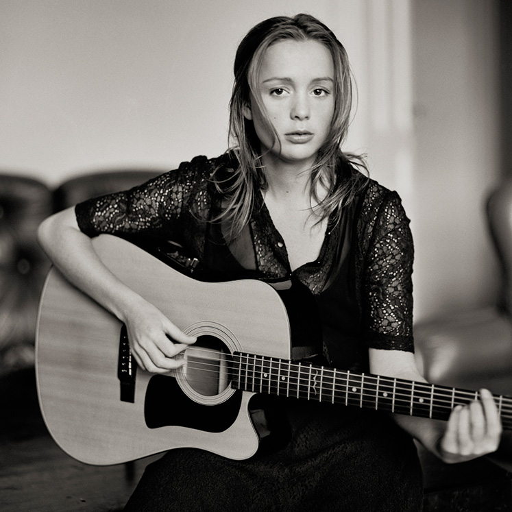 Artisten Lisa Ekdahl sitter med en gitarr