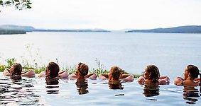 Vy från Orbaden spa och resorts pool med utsikt över vattnet.