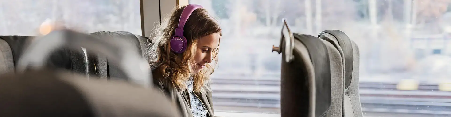 Kvinna med hörlurar åker tåg